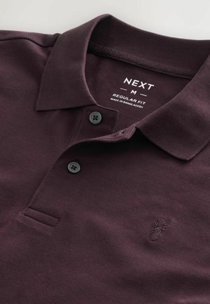 Cămașă polo de culoare vișinie închisă, cu un material texturat, având un guler clasic, două butoane negre și un mic logo embosat pe piept.