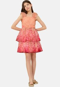 Robe florale rose avec des bretelles volantées, un haut ajusté et une jupe à volants. Présente un accent de ceinture ronde à la taille.