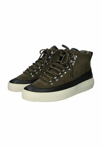 Sneaker alte in suede verde scuro con occhielli metallici e lacci. Presentano una punta in gomma nera e una spessa suola color crema.