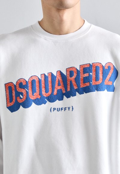 Hanorac alb cu un logo mare, texturat "DSQUARED2" în roșu, având un efect de umbră albastru, centrat pe piept, cu "Puffy" scris în litere mici dedesubt.