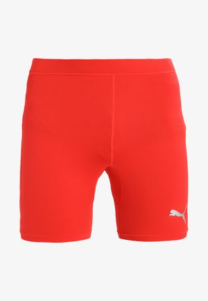 Rote Sportshorts aus dehnbarem Material mit glatter Textur. Auf der unteren rechten Seite des Beins befindet sich ein kleines weißes Logo. Länge bis zur Mitte des Oberschenkels.