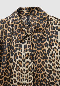 Blusa con stampa leopardata, colletto classico, chiusura con bottoni sul davanti e tessuto liscio e lucido. Presenta accenti in marrone scuro e chiaro.