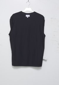 Mustassa lyhythihaisessa T-paidassa on pyöreä kaula-aukko, se on valmistettu pehmeästä kankaasta ja siinä on suora leikkaus sekä pieni lappu, joka näkyy helman kohdalla.