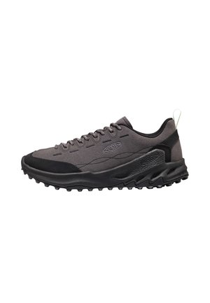 Zapato deportivo de perfil bajo en gris oscuro y negro con suela resistente, cierre de cordones y lengüeta en el talón para actividades al aire libre.