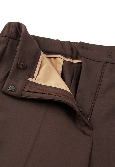 Tasche dei pantaloni marroni con zip, bottone e chiusura a gancio, che mostrano una fodera interna beige.