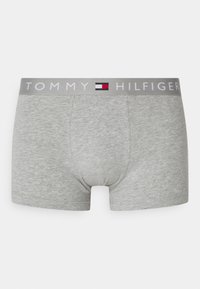 Boxers en coton gris au design ajusté. La ceinture élastique porte le logo "TOMMY HILFIGER" en blanc, souligné par un drapeau rouge et bleu.