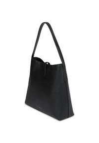 Melnas ādas rokassomas ar garu siksnu, minimālisma dizains un mazs zelta logotips netālu no apakšējā mala, skatījums no sāna uz baltā fona.