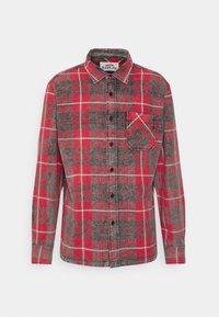 Camicia a quadri rossa e grigia in flanella, con chiusura frontale a bottoni, colletto e una tasca sul petto con lo stesso motivo a quadri.