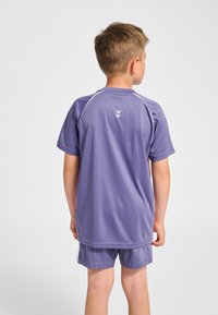 Lila sportt-shirt med korta ärmar och vita detaljer, med rund halsringning och en logga på baksidan. Matchas med randiga shorts.