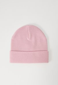 Bonnet en tricot rose clair avec revers, présenté sur un fond blanc uni.