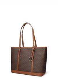 Borsa a mano marrone con monogramma e dettagli in pelle, dotata di manici lunghi e ciondolo dorato con logo MK. Texture liscia e forma strutturata.