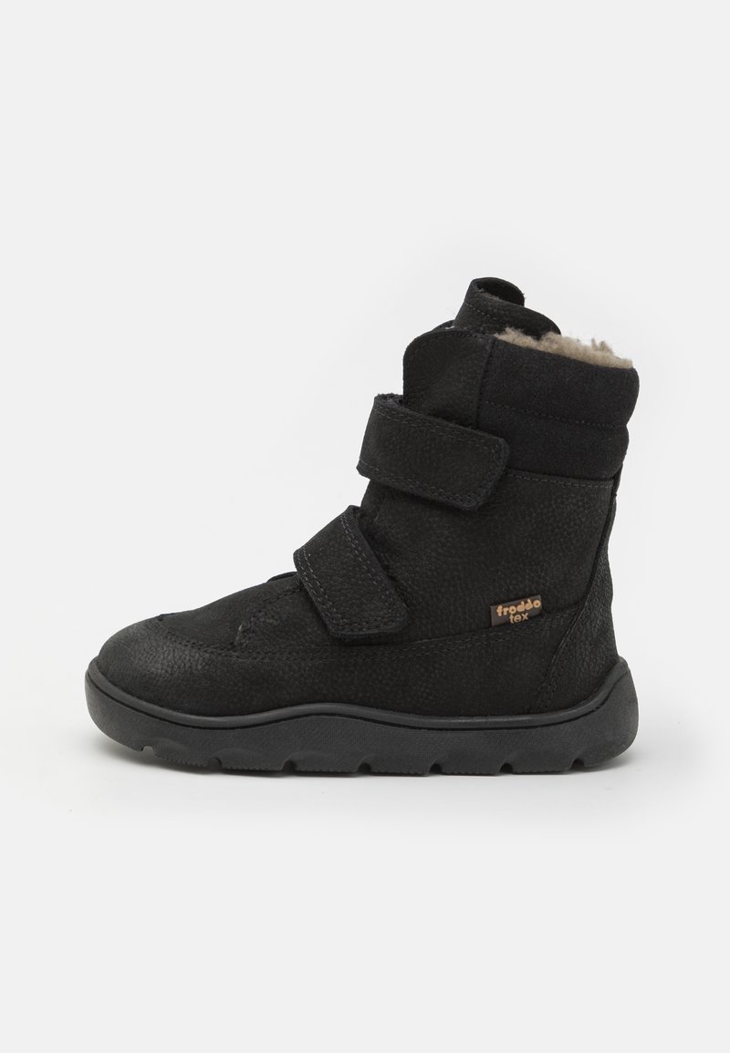 Botte d’hiver noire avec deux larges bandes Velcro, semelle texturée et doublure légère en polaire. Petite étiquette marron Froddo Tex sur le côté.