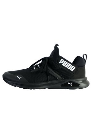 Baskets de sport Puma noires avec tige en mesh, semelle épaisse, lacets, et logo Puma blanc sur le côté et la zone des orteils.