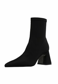 Bottines noires avec une tige en tissu extensible et élégant, bout pointu et un talon géométrique épais. Texture lisse avec finition mate.
