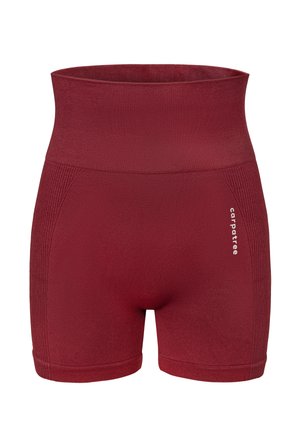 Crvene kratke hlače visokog struka izrađene od rastezljivog materijala. Imaju teksturirane bočne panele i otisnuti logo sprijeda. Glatki, prilagođeni dizajn.