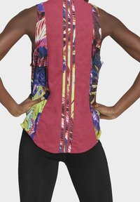 Mouwloos sporttopje met een levendig bloemmotief, een effen bordeauxrode achterkant en drie verticale strepen. Gemaakt van een gestructureerde stof met een losse pasvorm.