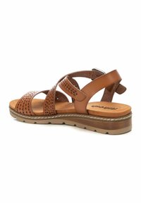 Sandal in pelle marrone con cinturini perforati, fibbia regolabile, soletta imbottita e suola in gomma testurizzata per una buona trazione.