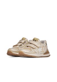 Zapatillas doradas para niños con correas de Velcro, diseño de estrellas en blanco y acentos dorados, material sintético suave, suela de goma marrón.