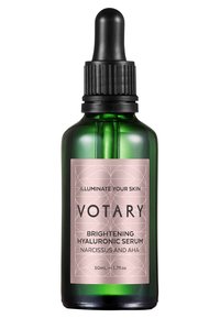 Grön glasflaska med en svart droppkork, har en rosa etikett med svart text som beskriver "Votary Brightening Hyaluronic Serum, 50mL."