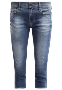 Light blue denim jeans with a faded finish, tapered ankle length, distressed detailing on front, and five-pocket design with subtle stitching.