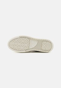 Guma podešev sneakers, s herringbone vzorem, texturovaným bílým povrchem a embosovaným logem.