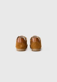 Bruine suède schoenen met leren accenten, gevoerde kraag en rubberen zool. Voorzien van gestikte details en een minimalistisch ontwerp.