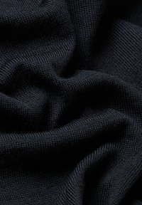 Tessuto a maglia scuro che mostra una consistenza liscia e uniforme con una leggera elasticità. Il colore uniforme è blu navy profondo, con pieghe e avvallamenti morbidi.
