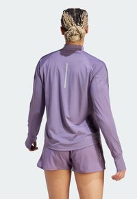 Lichtpaarse sportieve long-sleeve shirt met reflecterende details, gecombineerd met bijpassende gemêleerde shorts. Glad stof met ademend ontwerp.