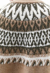Pull en tricot avec motifs géométriques en marron, blanc et vert foncé, avec des accents métalliques. Col montant et finition texturée.