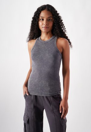Gray sleeveless top with a rounded neckline, featuring a soft, slightly textured fabric and a fitted shape, paired with dark cargo pants.