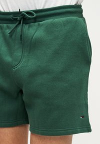 Πράσινα σορτς από βαμβακερό μείγμα με ελαστική μέση, ρυθμιζόμενο κορδόνι και πλαϊνές τσέπες. Διαθέτουν μικρό λογότυπο στο τελείωμα.