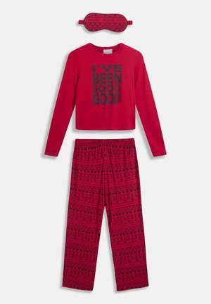 Červená souprava odpočinkového oblečení zahrnuje dlouhý rukáv s potiskem "BYL JSEM TAK DOBRÝ" v černé, vzorované kalhoty a odpovídající spánkovou masku.