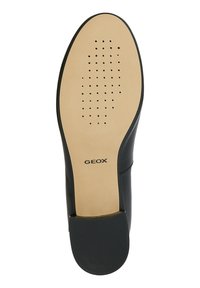 Suola nera delle scarpe con un design perforato per la traspirabilità, superficie beige liscia con logo e un tacco leggermente rialzato per la stabilità.