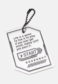 Étiquette de porte-clés avec une chaîne à billes noire, texte : "La vie est un jeu. Vivre, c'est jouer. Si jamais tu es bloqué, rejoue jusqu'à ce que tu réussisses."