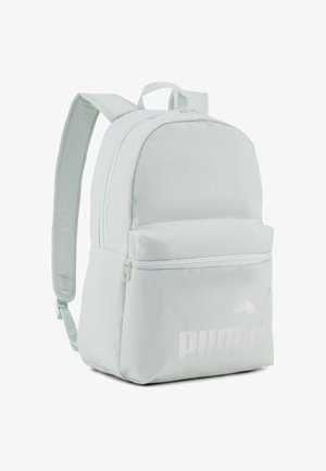 Zaino Puma grigio chiaro con due spallacci regolabili, una tasca frontale con zip e logo Puma discreto nell’angolo in basso a destra.