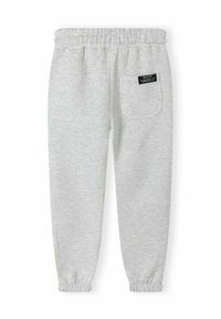 Grijze joggingsbroek met elastische tailleband en enkels. Heeft een achterzak met een zwart label. Gemaakt van zachte, gestructureerde stof.