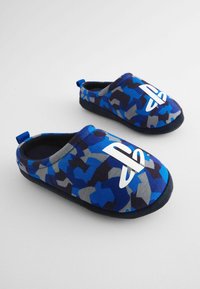 Blå og grå camouflage slippers med et hvidt logo, blødt stofoberste, slip-on design og kontrasterende sort sål.