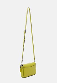 Borsa a tracolla gialla con una superficie liscia, forma rettangolare e dettagli neri. Presenta una lunga tracolla regolabile e hardware argentato.