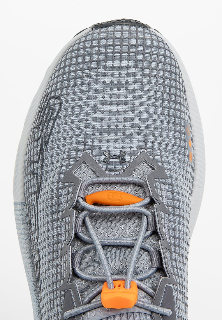 Szare siatkowe buty sportowe z elastycznymi sznurowadłami zabezpieczonymi pomarańczowym złączem i logo Under Armour na języku oraz boku.