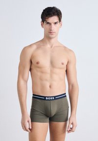 Olive green boxer shorts with a navy and white BOSS logo waistband. Soft, stretch fabric with a fitted design.