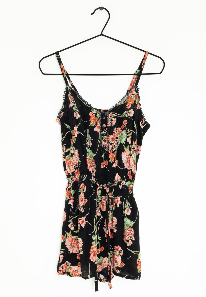 Černý květinový overal s nastavitelnými ramínky, zdobený růžovými a zelenými květinovými vzory, s nařaseným pasem a vázacím detailem.