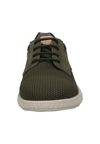 Scarpa in rete verde con accenti in suede, caratterizzata da lacci rotondi, una suola in gomma crema e un piccolo logo impresso sulla linguetta.
