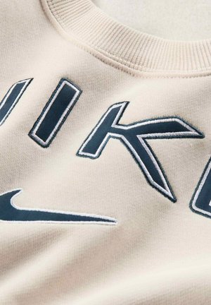 Felpa beige con ricamo in blu scuro della scritta "NIKE" e logo. Collo a costine. Texture morbida e liscia.