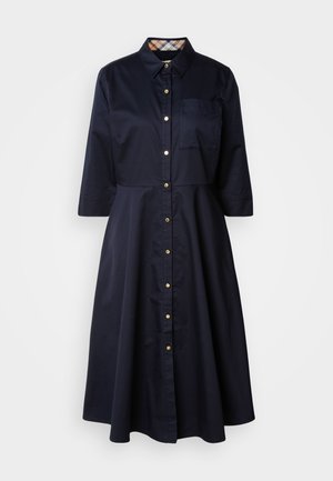 Marineblauwe katoenen shirtjurk met knoopsluiting aan de voorkant, puntige kraag, driekwart mouwen en een borstzak. Kenmerkt zich door een ruitpatroon op de kraag.