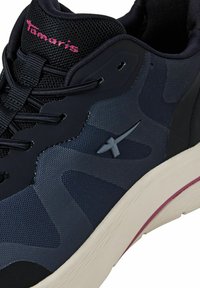 Scarpa da uomo sportiva navy con tomaia in rete testurizzata, dettagli neri, lacci visibili e suola leggera con una striscia rosa, marchiata "Tamaris."