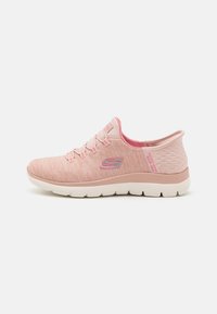 Scarpa sportiva rosa chiaro con tomaia texturizzata, chiusura con lacci frontale, collare imbottito e suola ammortizzata. Presenta un accento del logo in argento lucido.