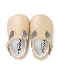 Scarpe per bambini in pelle beige, con lati intagliati, chiusura a fibbia e dettagli perforati sulla punta e attorno all'apertura.