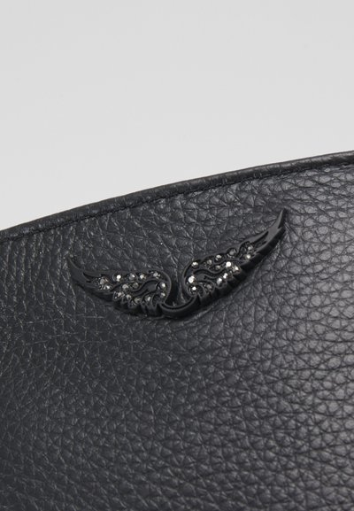 Materiale in pelle nera texture con un distintivo alato nero dettagliato impreziosito da accenti in cristallo. Il design include motivi intricati.
