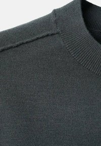 Mörkgrå stickad tröja med ribbat rundutskuret halsband och distinkta axelsömmar, tillverkad av mjukt material med en texturerad yta.