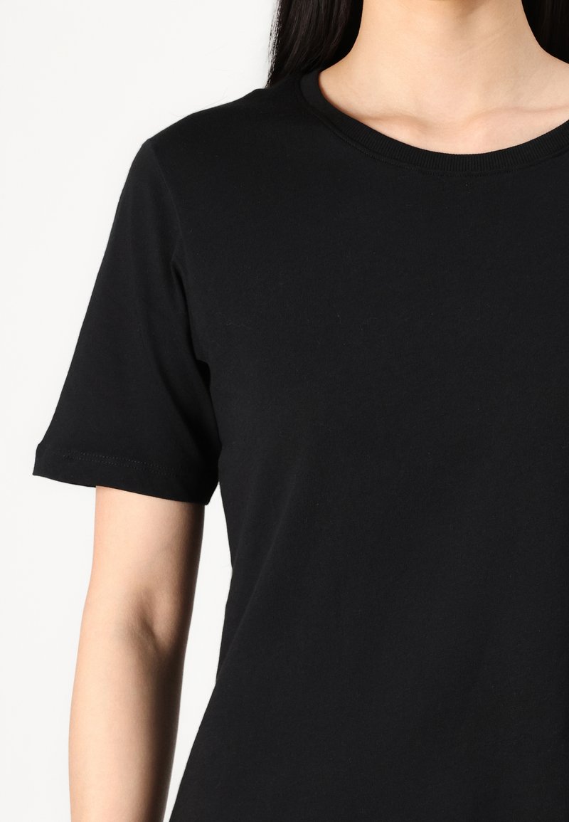 T-shirt en coton noir avec un col rond et des manches courtes. Texture lisse sans motifs ni accents visibles. Design simple et classique.